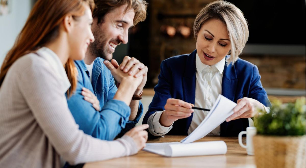 real agent young couple going through lease agreement while having meeting home